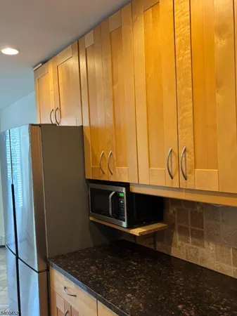 a bathroom with a granite countertop sink and a washing machine