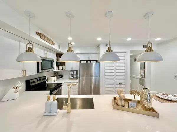 a kitchen with refrigerator and chairs