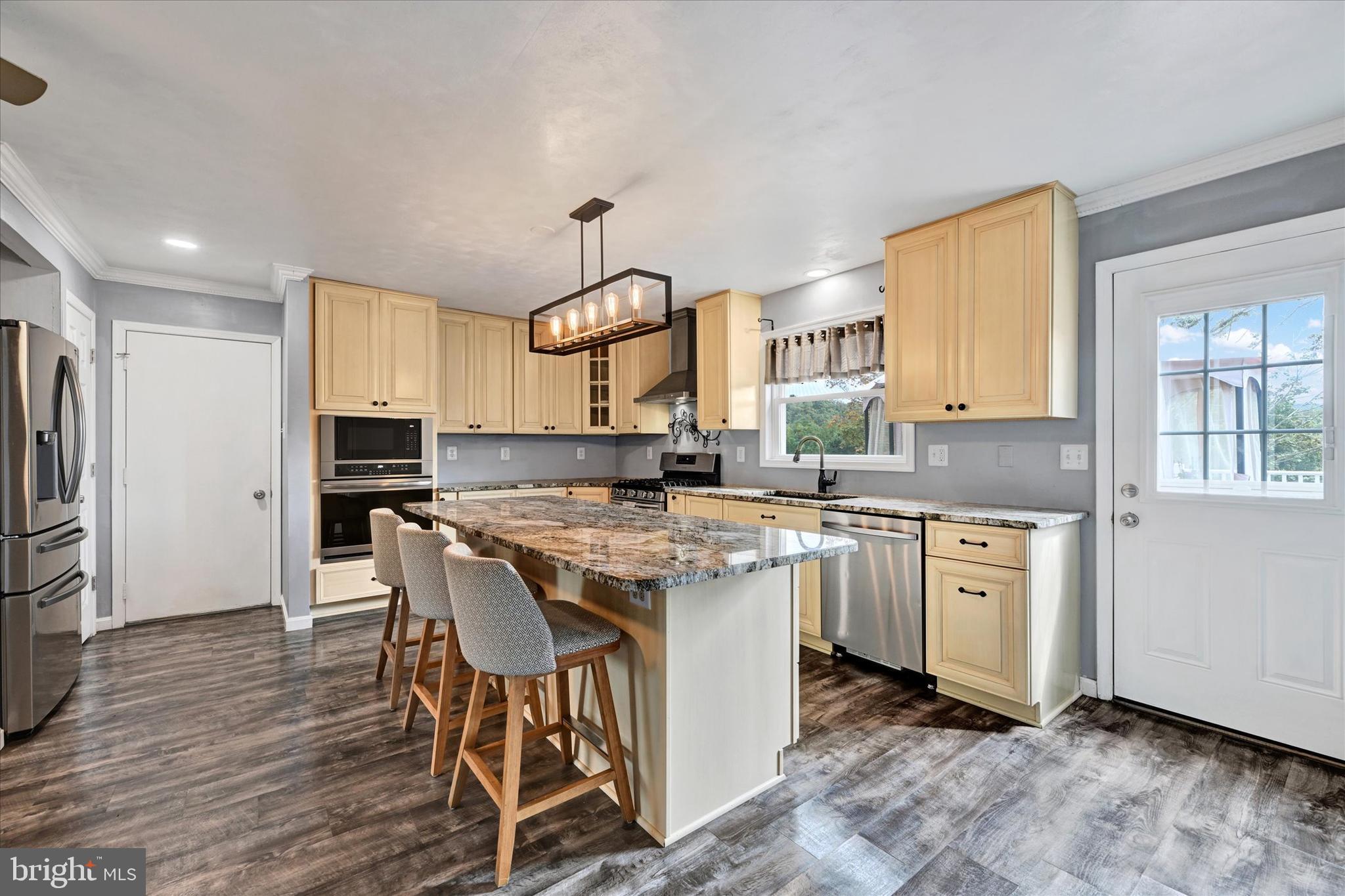 1485 Bachmans Valley Road Westminster, MD 21158 - Photo 16 of 60 a kitchen with stainless steel appliances granite countertop a kitchen island hardwood floor sink and stove
