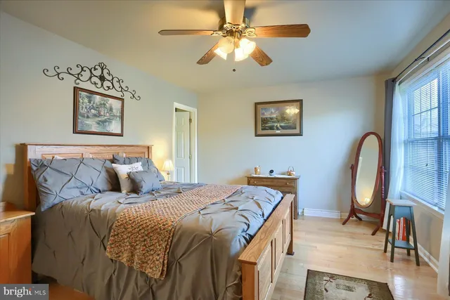 a bed sitting in a bedroom next to a window with a chandelier