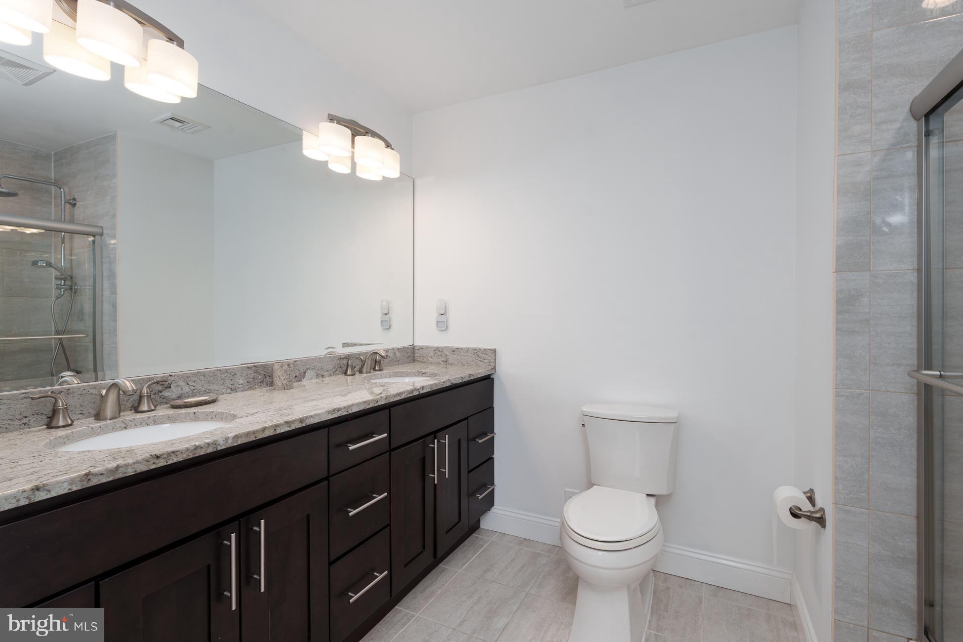 6 Andrews Lane Princeton, NJ 08540 - Photo 20 of 27 a bathroom with a granite countertop toilet a sink and a mirror