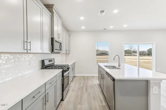 a kitchen with stainless steel appliances a sink and a large window