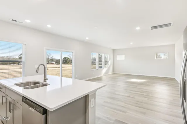 a view of kitchen with center island stainless steel appliances refrigerator sink and cabinets