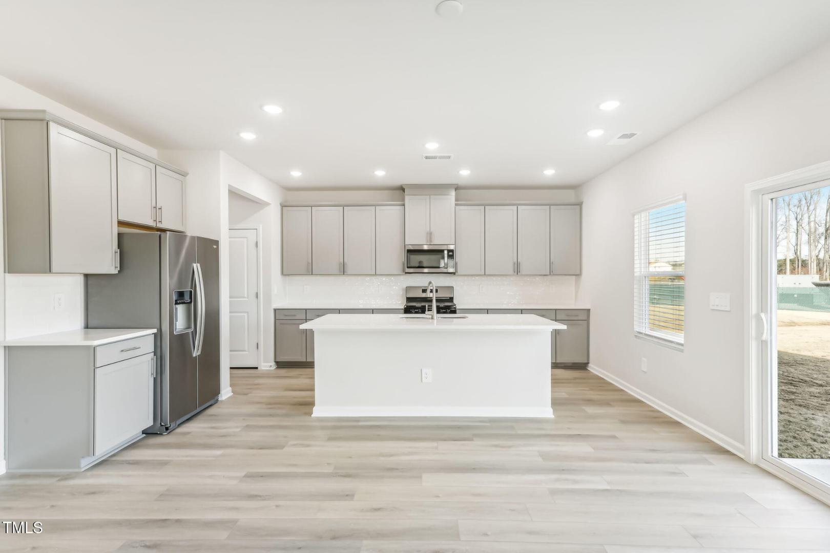 191 White Birch Lane Angier, NC 27501 - Photo 29 of 35 a view of kitchen with center island stainless steel appliances refrigerator sink and cabinets