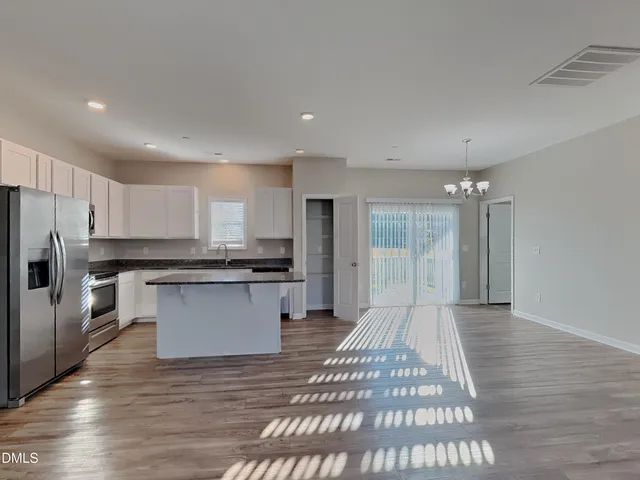 a large kitchen with kitchen island a sink stainless steel appliances and cabinets