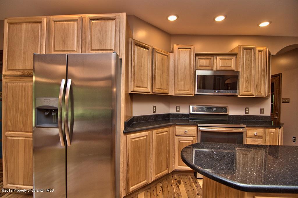 16 Pine Ridge Road Tunkhannock, PA 18657 - Photo 26 of 86 a kitchen with stainless steel appliances granite countertop a refrigerator a stove and a sink with wooden floor