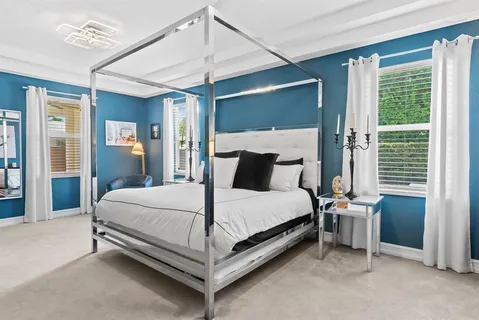 a bed sitting in a bedroom next to a window