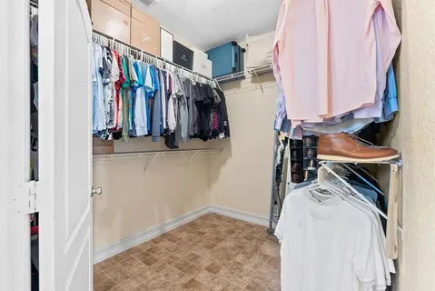 a view of walk in closet with clothes and shoes