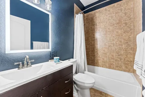 a bathroom with a sink toilet and shower