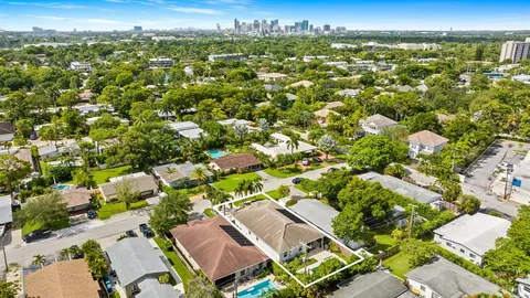 an aerial view of residential houses with outdoor space and trees