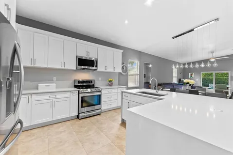 a kitchen with granite countertop a stove sink and cabinets