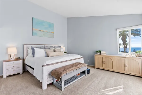 a spacious bedroom with a bed and a dresser