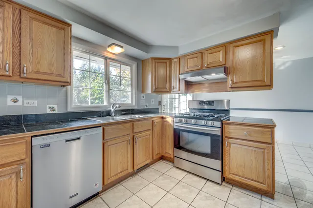 a kitchen with stainless steel appliances granite countertop a sink and a stove