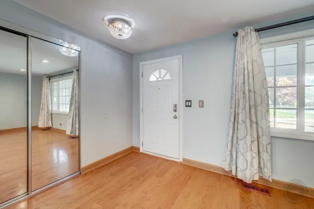 a view of an empty room with window and wooden floor