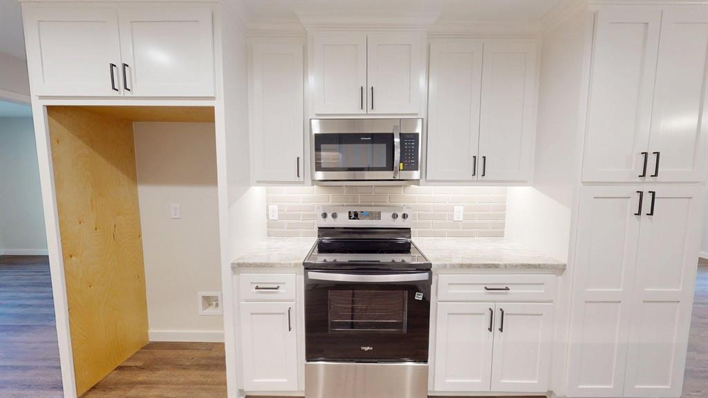 1110 Mill Run Road Athens, TX 75751 - Photo 8 of 32 a kitchen with cabinets stainless steel appliances and a wooden floor