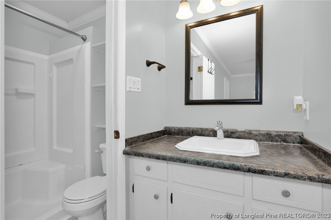 3675 Applegate Road Hope Mills, NC 28348 - Photo 17 of 32 a bathroom with a granite countertop sink a toilet and a mirror