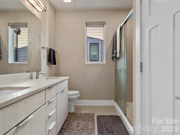 a bathroom with a granite countertop sink toilet a mirror and shower