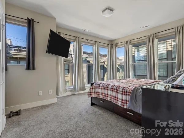 a bed sitting in a spacious bedroom next to a window