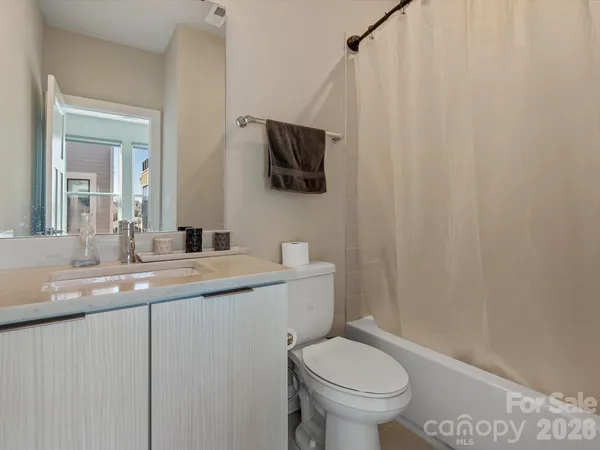 a bathroom with a granite countertop sink a toilet and a mirror