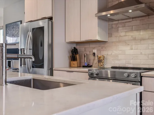 a kitchen with stainless steel appliances granite countertop a sink and a stove