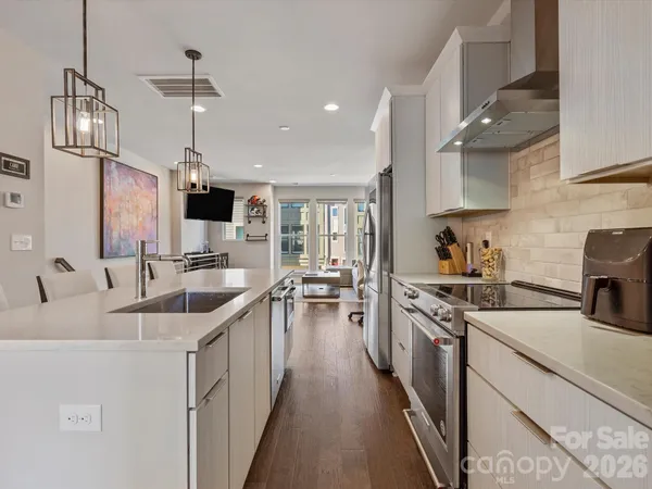 a kitchen with granite countertop a sink a counter space appliances and cabinets