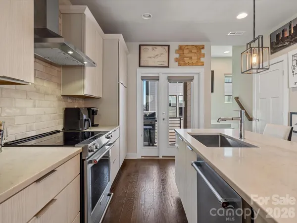a kitchen with granite countertop a sink stove and refrigerator