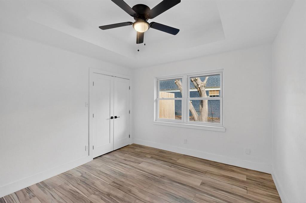 1808 Greenwood Road McKinney, TX 75069 - Photo 25 of 40 an empty room with wooden floor chandelier fan and windows