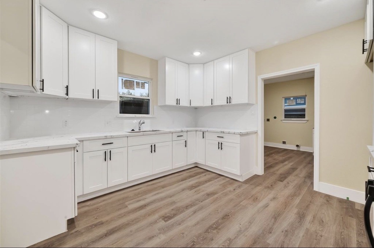 2725 Avenue F Rosenberg, TX 77471 - Photo 7 of 17 a kitchen with a sink cabinets and wooden floor