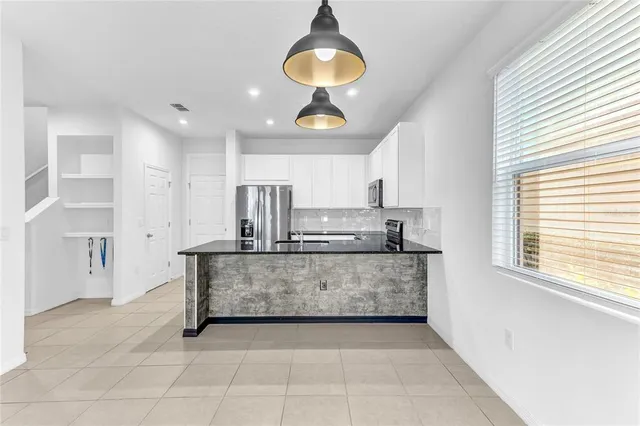 a kitchen with stainless steel appliances granite countertop a stove a sink and a refrigerator