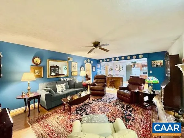 a kitchen with stainless steel appliances granite countertop a stove a refrigerator a sink dishwasher a dining table and chairs with wooden floor