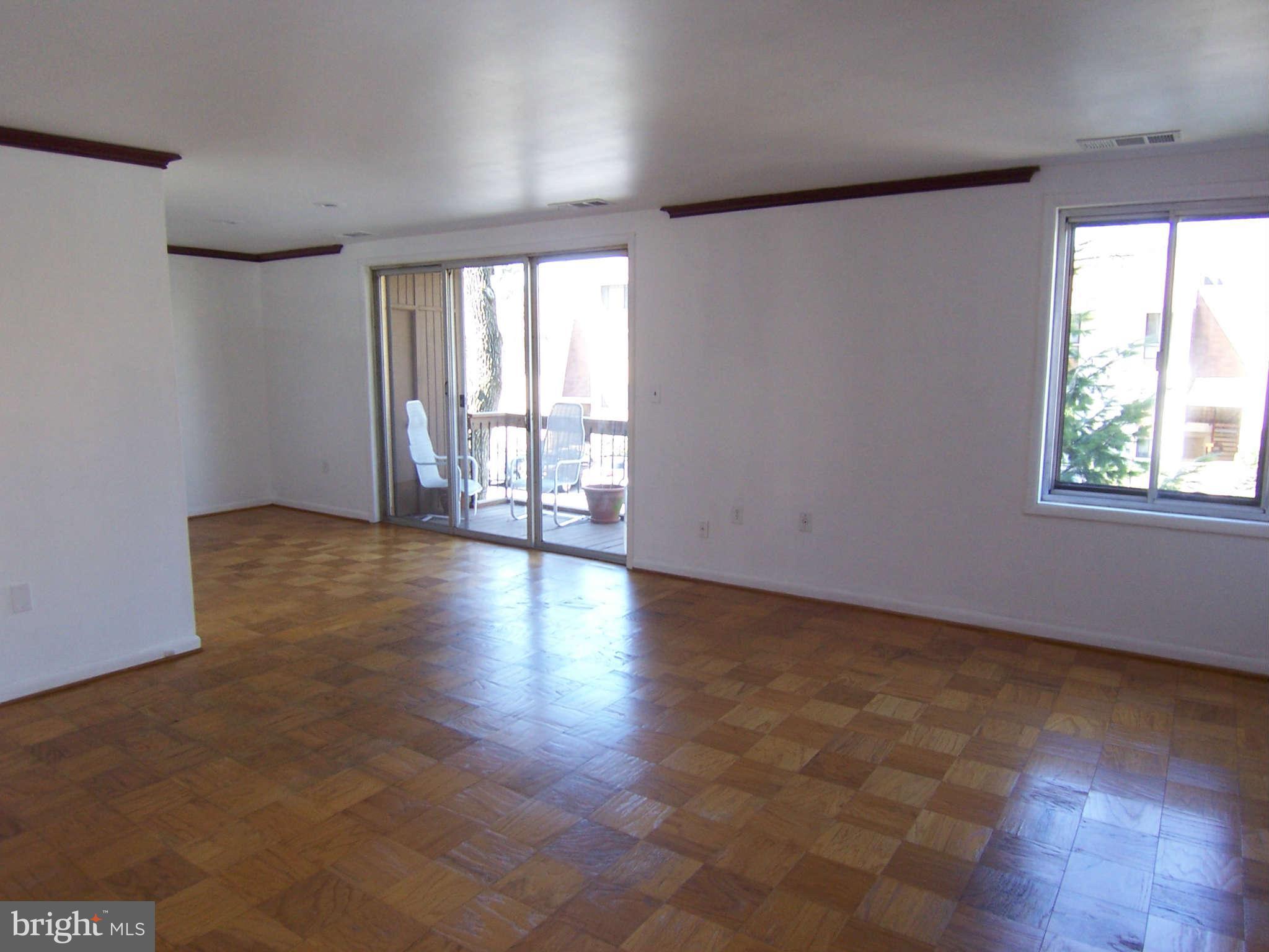 5 Cross Keys Road, Unit 5D Baltimore, MD 21210 - Photo 4 of 16 a view of an empty room with wooden floor and a window