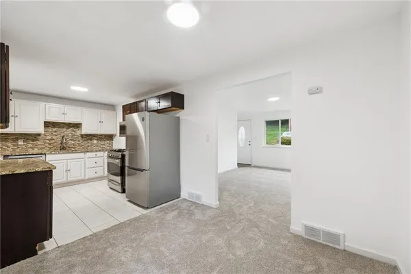 a view of kitchen with refrigerator stove microwave and cabinets