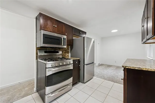 a kitchen with granite countertop a stove and a refrigerator