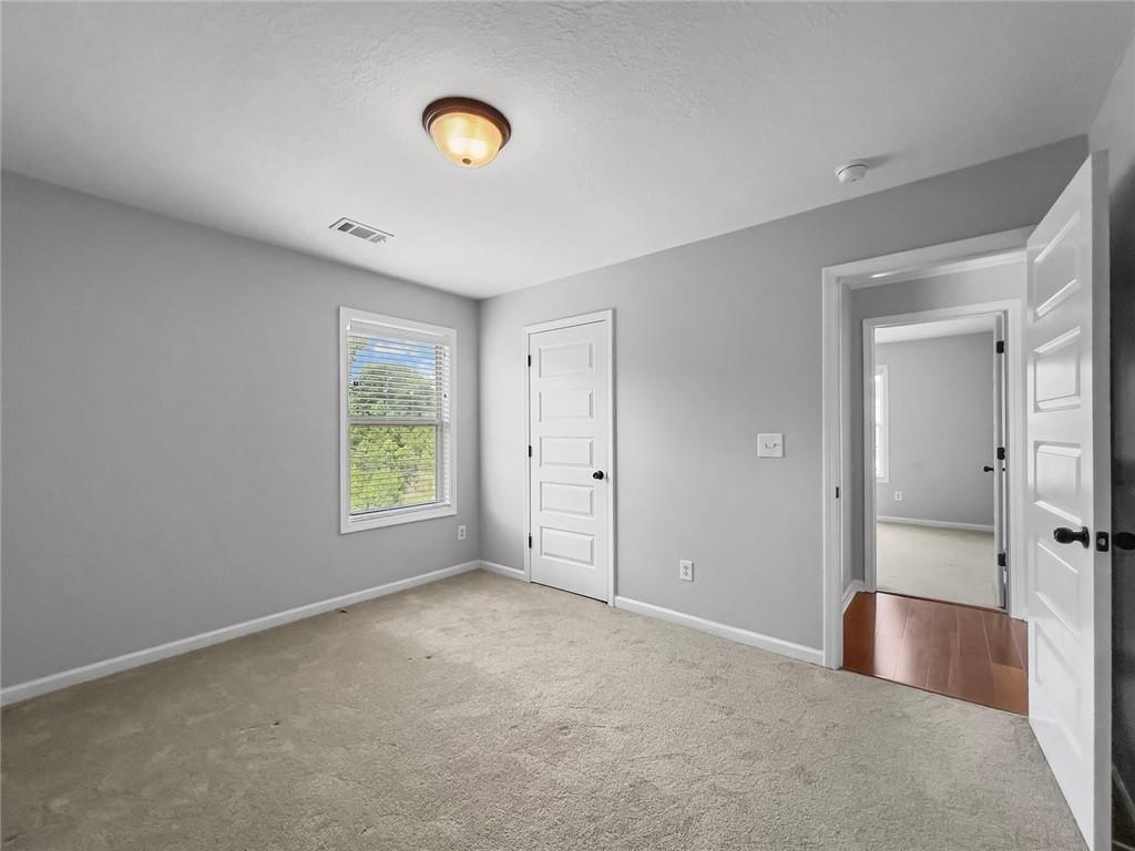 6 Pebblebrook Lane Fort Mitchell, AL 36856 - Photo 27 of 48 Unfurnished bedroom featuring carpet, a textured ceiling, and a closet