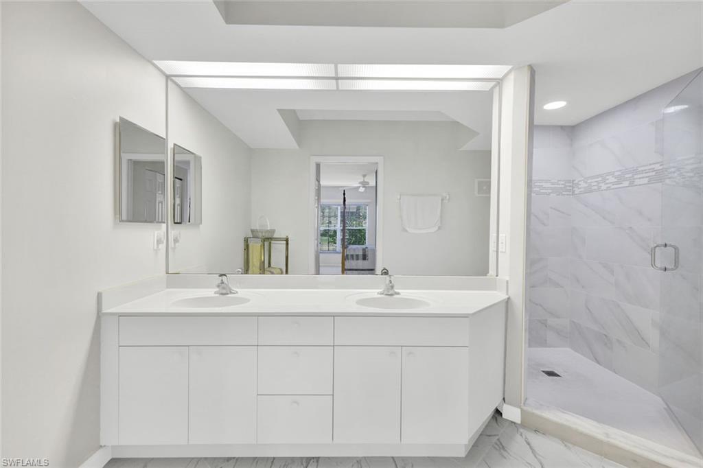 23731 Old Port Road, Unit 103 Estero, FL 34135 - Photo 12 of 30 a bathroom with a sink double vanity mirror and a bathtub