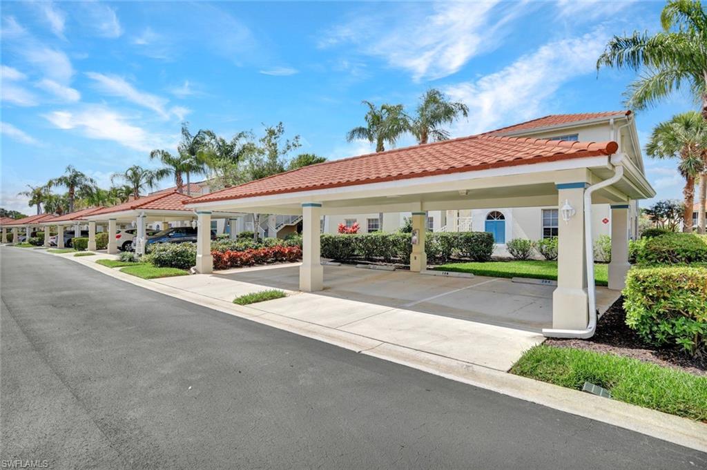23731 Old Port Road, Unit 103 Estero, FL 34135 - Photo 18 of 30 a front view of a house with a yard and potted plants