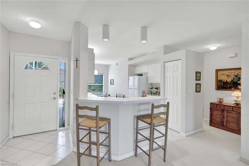 23731 Old Port Road, Unit 103 Estero, FL 34135 - Photo 6 of 30 a kitchen with stainless steel appliances a refrigerator and a stove top oven