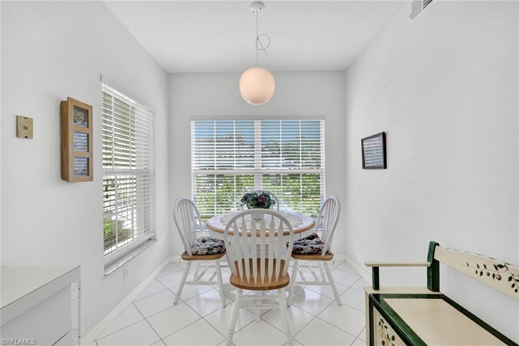 23731 Old Port Road, Unit 103 Estero, FL 34135 - Photo 9 of 30 a view of a dining room with furniture wooden floor and a chandelier