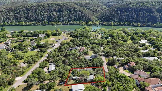 an aerial view of a house with a yard and lake view