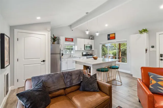 a view of kitchen with stainless steel appliances kitchen island a stove a sink a refrigerator and cabinets