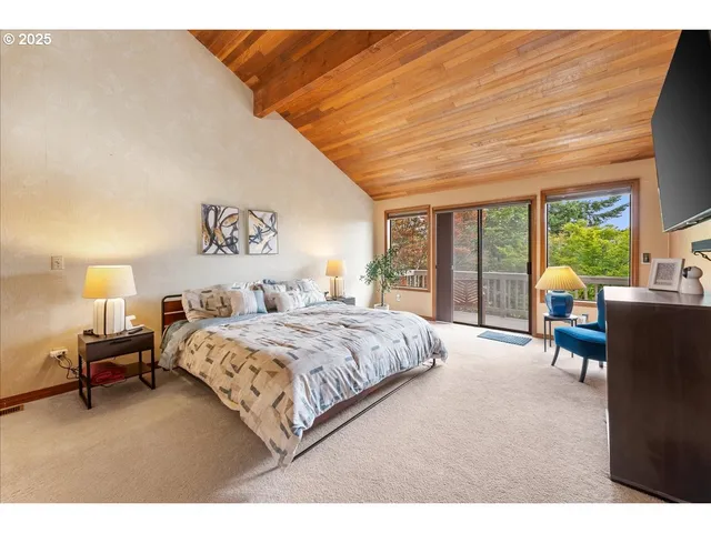 a bedroom with a bed and large windows