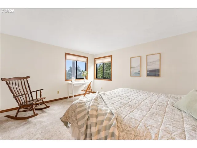 a bedroom with a bed a chair and next to a window