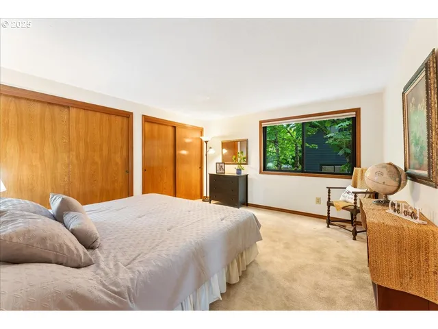 a bedroom with a bed and large windows