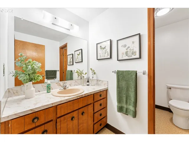 a bathroom with a granite countertop sink mirror and toilet