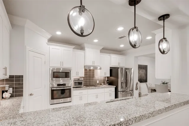a large kitchen with a refrigerator a sink and cabinets