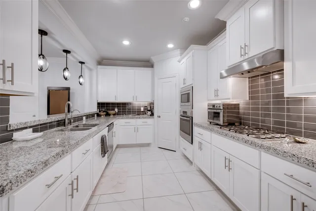 a kitchen with granite countertop white cabinets and white stainless steel appliances