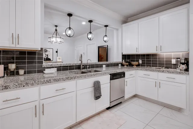 a kitchen with granite countertop a sink stainless steel appliances and cabinets