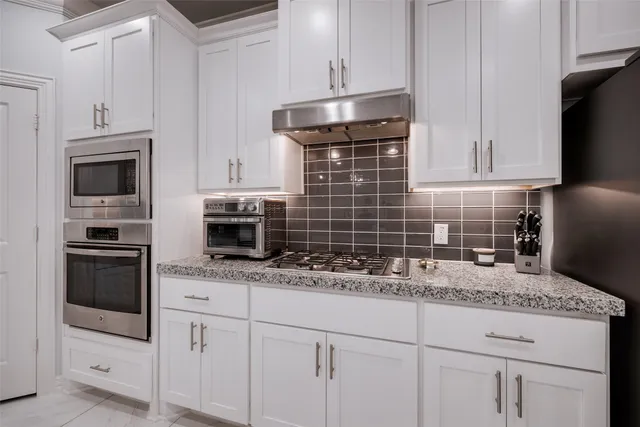 a kitchen with stainless steel appliances granite countertop a sink refrigerator and cabinets