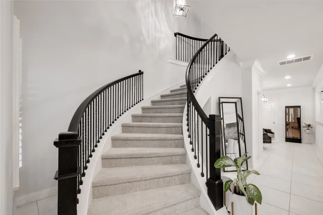 a view of staircase with railing and white walls