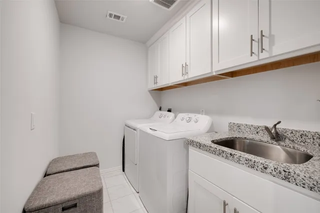 a bedroom with a bed a chandelier and a couch